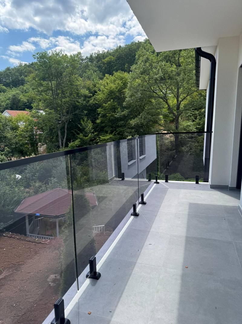 Gilindera xhami në tarracë. Gilindera me xham transparent përgjatë një tarrace të gjatë.